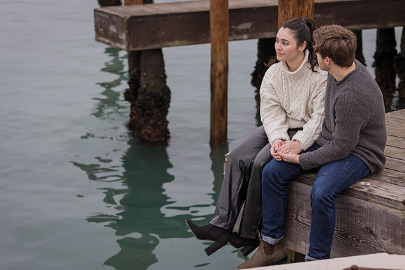 Couple sitting by dockside reflecting on special moment