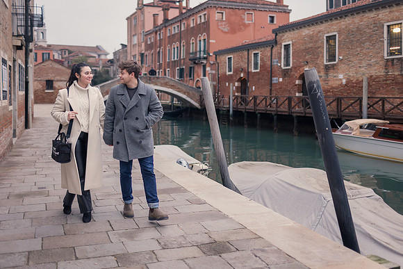 Couple walking together along Venice canal in winter