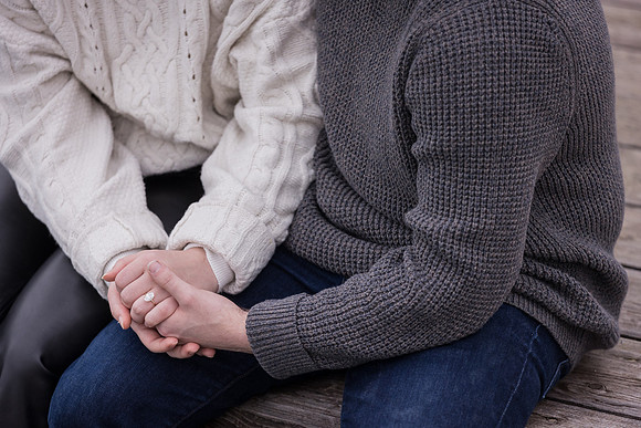 Close-up of couple holding hands, reflecting on engagement