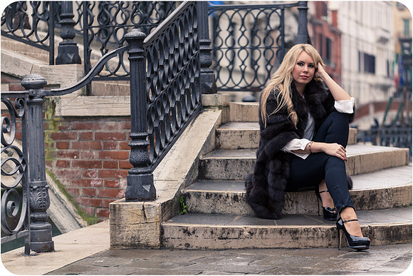 Stylish pose on Venetian bridge in winter