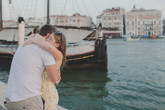 Engaged couple hugging with Venice skyline in the background