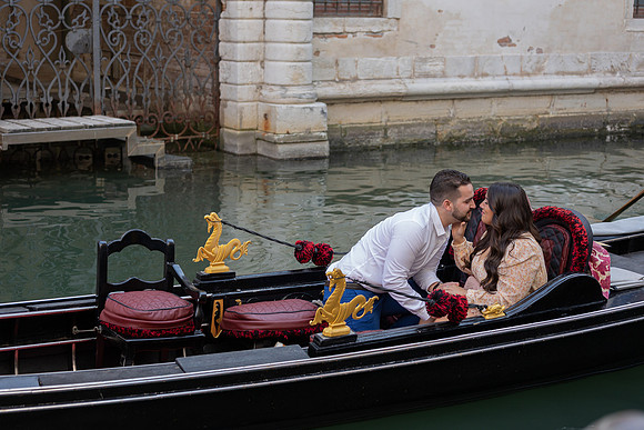 Couple in gondola with Venice canal in background
