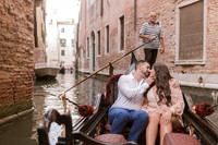 Couple sharing a kiss on a gondola in Venice