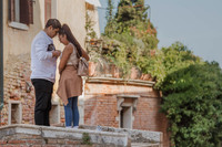 A groom-to-be kneels on one knee, proposing on Venice’s only bridge without railings.