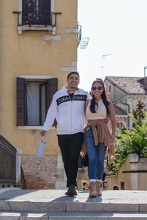 The couple walks along the historic streets of Cannaregio, savoring the moment.