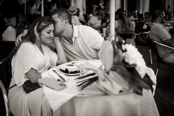 Engaged couple whispering at Café Florian