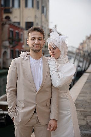Couple standing side by side, posing for their engagement session in Venice.