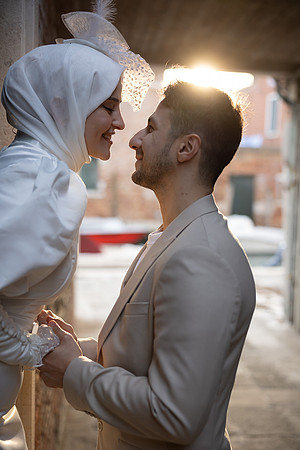 Engaged couple laughing together in an alley in Venice.