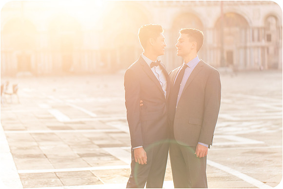 Couple embracing in Piazza San Marco during sunrise.