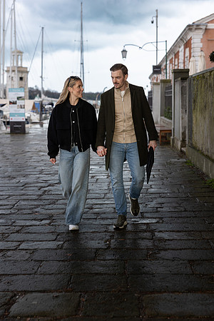 The couple strolls through Venice’s stone streets, relishing their engagement glow.
