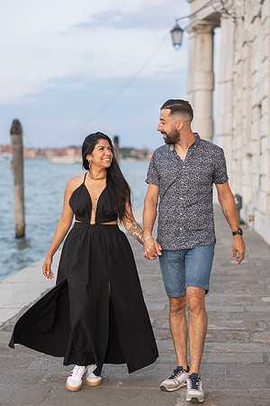 Couple walking along Grand Canal after proposal in Punta della Dogana.