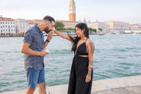 Groom kissing fiancée’s hand after successful surprise proposal.
