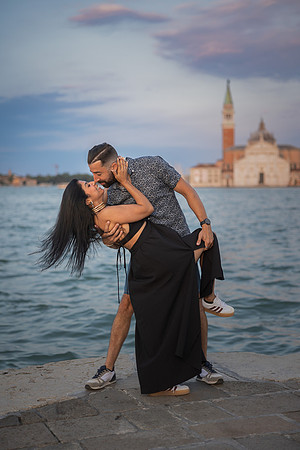 Couple dancing and laughing at sunset after surprise engagement.