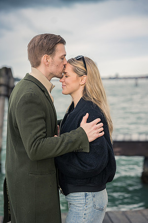 A sweet kiss between the couple, with the Venetian skyline in the distance.