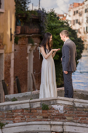 Couple walking together after engagement on a Venetian bridge.