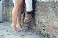 A romantic moment featuring intertwined legs and elegant footwear.