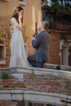 Man proposing on Ponte Chiodo bridge in Venice at sunset.