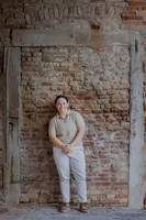 A woman posing against a textured brick wall in Venice.