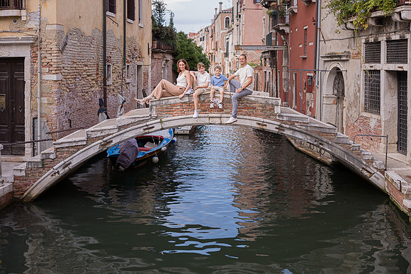Family by the canal in Cannaregio, Venice enjoying a quiet moment.