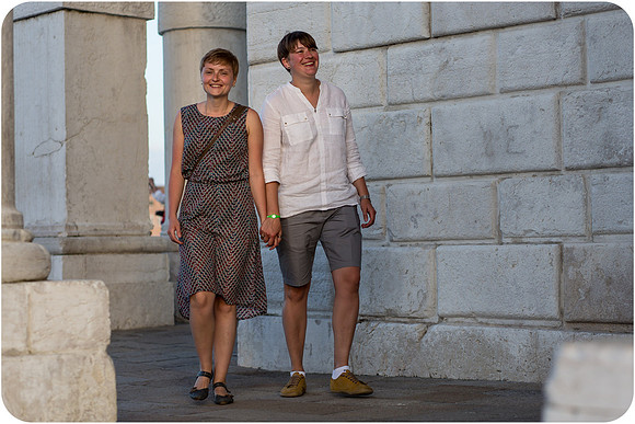Lesbian couple enjoying a romantic summer afternoon in Venice, embracing love in a stunning setting.
