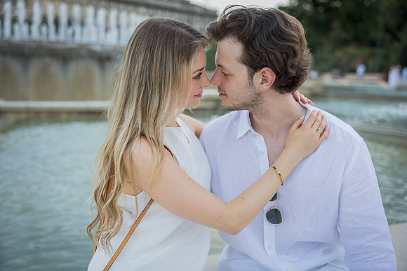 Romantic couple seated by Milan fountain