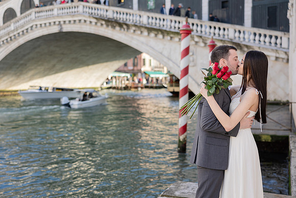 Couple posing near Rialto Bridge in Venice after their proposal.