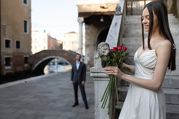 Couple walking together on a bridge in Venice after proposal.