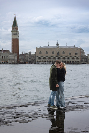 A romantic moment captured as the couple stands over a beautiful reflection of Venice.