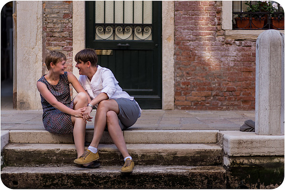 Lesbian woman sitting on the steps of a historic building in Venice.