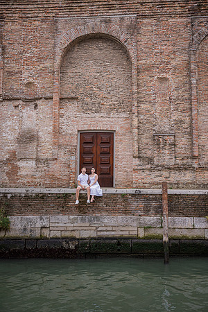 Couple leaning against a brick wall in Venice during engagement shoot