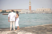 A newly engaged couple celebrates with a sunset kiss in Venice.