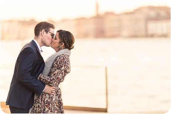Couple sitting inside a Venetian water taxi, sharing a romantic moment.