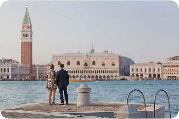 Man proposing to his partner near the waterfront with Venice’s landmarks behind them.