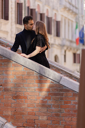 Couple walking along a historic street in Venice, smiling.