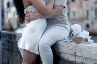 Same-sex couple sitting together, sharing an intimate hug.