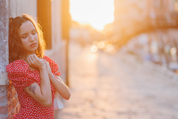 Model leaning against a wall at sunset in Venice.