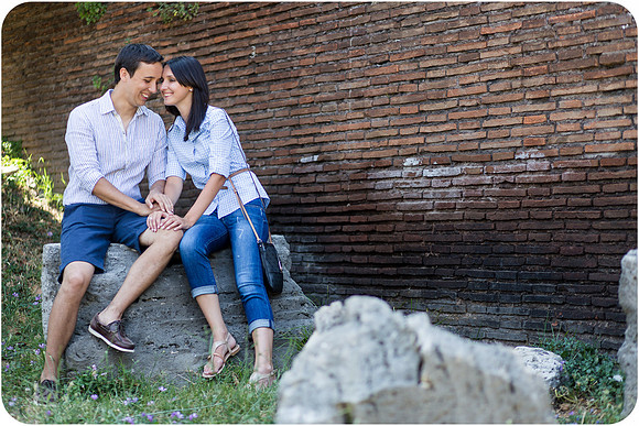 Honeymoon couple posing by a Roman wall in the summer