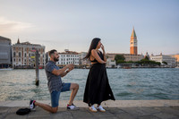 Surprised woman reacts during romantic proposal near St. Mark’s tower.