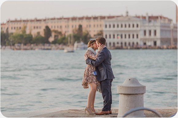 Couple walking along the waterfront with St. Mark’s Campanile in the background.