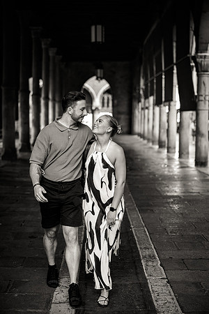Black and white stroll under Venetian arches after proposal