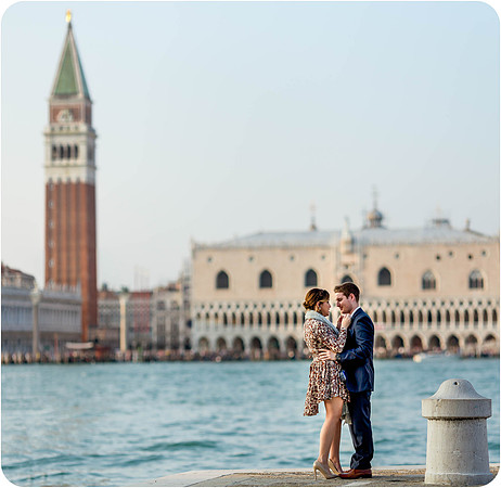 Couple standing close by the waterfront, lost in their love.