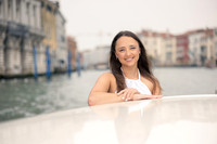 A couple embraces after a surprise engagement by the Venetian waterfront.