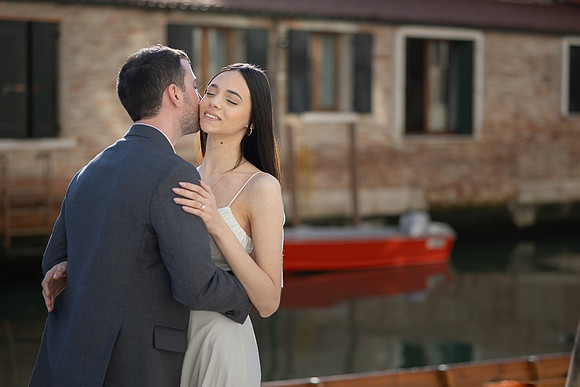 Couple standing quietly on a small Venetian bridge.