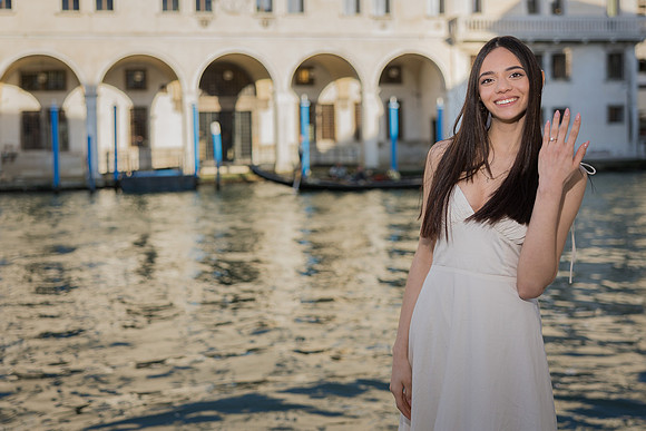 Woman in white dress smiling near the Grand Canal in Venice.