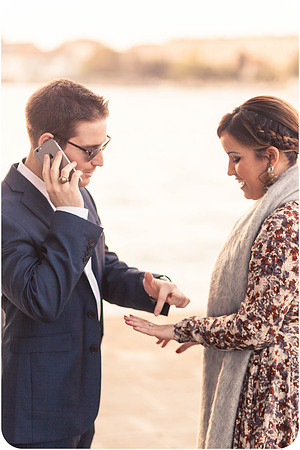 Man placing the engagement ring on his partner’s finger in Venice.