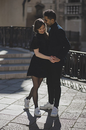 Couple walking on a Venetian bridge, enjoying a romantic moment.