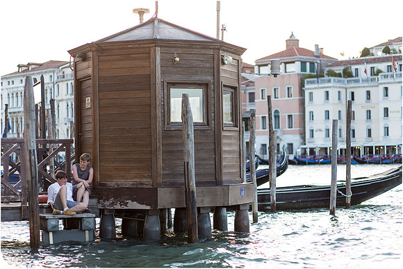 Lesbian couple enjoying a romantic summer afternoon in Venice, embracing love in a stunning setting.