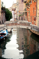 Couple sitting by canal in Venice during engagement