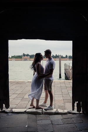 Engaged couple holding hands at a Venetian pier
