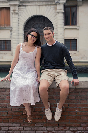 Engaged couple sitting by traditional Venetian architecture